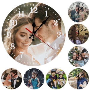 May include: A collection of round wall clocks featuring personalized photos. The main clock displays a couple, with black hands and red second hand. Other clocks show various family photos, with white numerals and black hands.