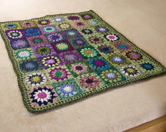 Könnte beinhalten: Eine handgefertigte, quadratische Häkeldecke mit einem Patchwork-Design aus bunten Blumenquadraten. Die Decke zeigt eine Vielzahl von Farben, darunter Lila, Grün, Blau und Rosa, mit einem dunkelgrünen Rand. Die Decke ist etwa 100 cm groß.