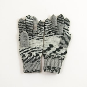 May include: A pair of gray and black knit gloves with a geometric pattern.