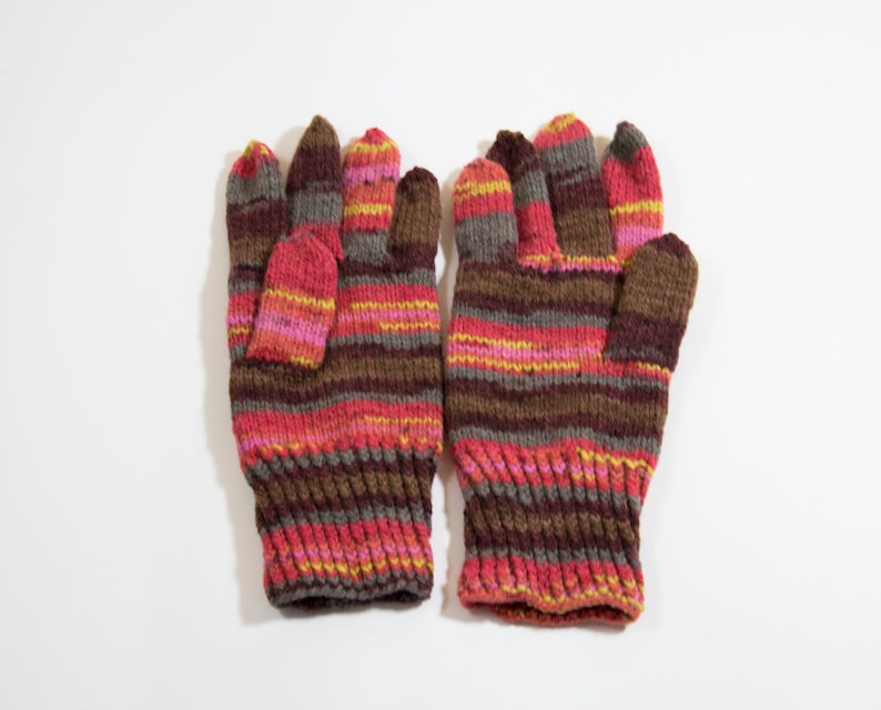 May include: A pair of striped knit gloves in brown, pink, and yellow.