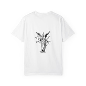 Puede incluir: Camiseta blanca con una ilustración en blanco y negro de una figura alada con múltiples brazos. La obra de arte está centrada en la parte trasera de la camiseta, creando un llamativo contraste con la tela blanca lisa. La camiseta tiene un cuello redondo clásico.