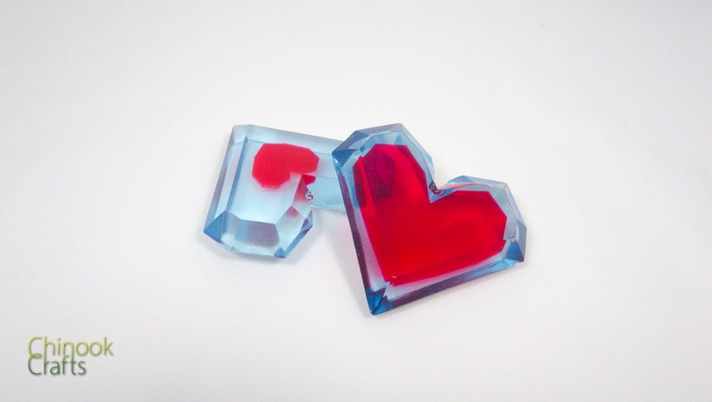 Pu&ograve; includere: Due ornamenti in resina a forma di cuore, uno &egrave; blu con un cuore rosso all'interno, l'altro &egrave; rosso con un contorno blu.