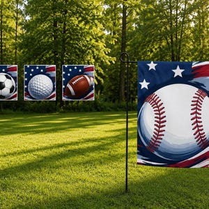 Könnte beinhalten: Eine rechteckige Gartenflagge mit einem großen weißen Baseball mit roten Nähten, zentriert vor einem blauen Hintergrund mit weißen Sternen sowie roten und weißen Streifen. Die Flagge ist an einem schwarzen Metallständer befestigt.