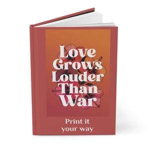 Könnte beinhalten: Ein rotes Hardcover-Journal mit weißen Seiten. Auf der Vorderseite steht der Text "Love Grows Louder Than War" in Weiß, mit floralen Illustrationen. Auf der Unterseite des Journals steht "Print it your way".