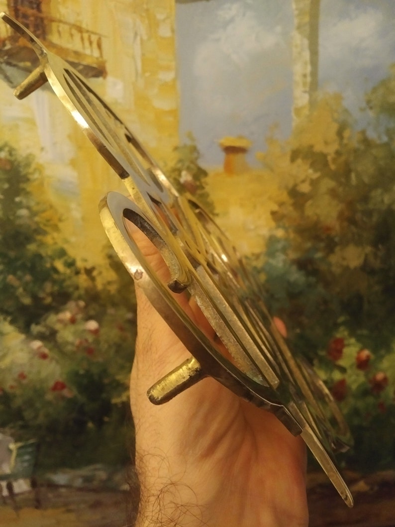 K&ouml;nnte beinhalten: Ein goldfarbenes Metallschild mit dem Wort "Good" in einer dekorativen Schriftart. Das Schild hat zwei kleine Metalllaschen an der Unterseite zum Aufh&auml;ngen.
