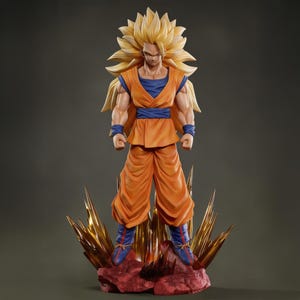 Puede incluir: Figura detallada de un personaje con cabello dorado puntiagudo y atuendo naranja. La figura se encuentra sobre una base rocosa con detalles dorados. El atuendo del personaje incluye una camiseta interior azul, pantalones naranjas y muñequeras y tobilleras azules.