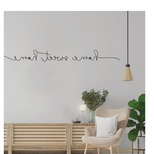 Letrero de pared minimalista con la frase "Home Sweet Home" (Hogar dulce hogar) en alambre metálico, ideal para la entrada.
