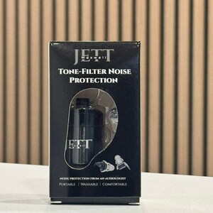May include: A black box with the text "JETT Maxwell Tone-Filter Noise Protection" features a diagram of an ear and earplugs. The box also states "Noise Protection From An Audiologist" and lists "Portable, Washable, Comfortable."
