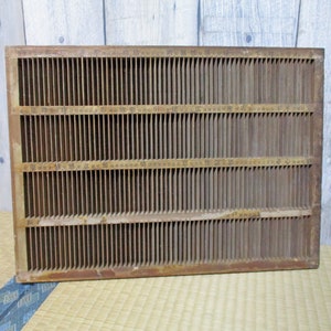 May include: A wooden storage box with a grid of compartments. The box is made of brown wood and has a rectangular shape. The compartments are numbered.