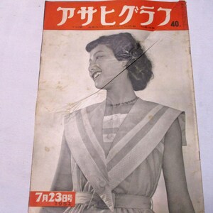May include: A vintage 1952 Asahi Graph magazine cover featuring a black and white portrait of a person with short dark hair wearing a collared dress with a wide lapel. The top banner is orange with white Japanese text and the number 40.