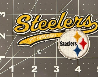 May include: An embroidered patch featuring the word Steelers in yellow cursive script with black outlines, a yellow banner with the word Pittsburgh, and a circular patch with the Steelers logo containing yellow, red, and blue diamonds.