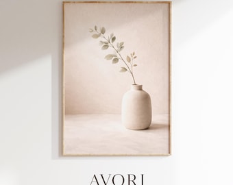 May include: A framed wall art print featuring a beige ceramic vase holding a single leafy branch. The composition is set against a textured, light-colored background with soft shadows. The text AVORI STUDIO is printed in dark brown at the bottom.