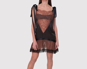 May include: A short dress featuring a brown lace bodice with a V-shaped black satin panel, black satin shoulder ties, and a brown lace skirt section with a black lace hem. The garment has a straight neckline and a layered, semi-sheer construction.