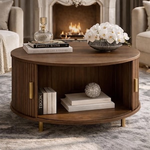 Peut inclure: Une table basse ronde en bois foncé avec un design latéral à lattes et des pieds dorés. La table comporte une étagère inférieure et est décorée de livres, d'un globe décoratif et d'un vase d'orchidées blanches. Un flacon de parfum en verre est posé dessus.