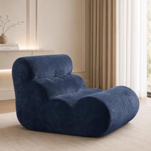 May include: A modern, navy blue velvet armchair with a unique, curved design. The chair features a rounded back and seat, offering a stylish and comfortable seating option for a living room or lounge area.