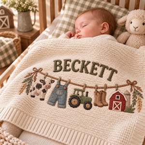 May include: A cream-colored knit baby blanket featuring the name BECKETT embroidered in dark green. The blanket displays a decorative clothesline with a cow, blue denim overalls, a green tractor, brown boots, and a red barn with a silo.