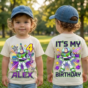 May include: A cream-coloured t-shirt featuring a graphic of Buzz Lightyear, a birthday cake, the number 4, and the name ALEX on the front, with the text IT'S MY BIRTHDAY and a graphic of Buzz Lightyear on the back, worn with a blue baseball cap.