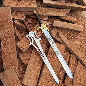 May include: Two metal swords with pointed blades and ornate crossguards. One sword features a brown leather-wrapped handle and silver-toned guard, while the other has a black handle and a gold-toned guard with the text VIKING engraved on the blade.