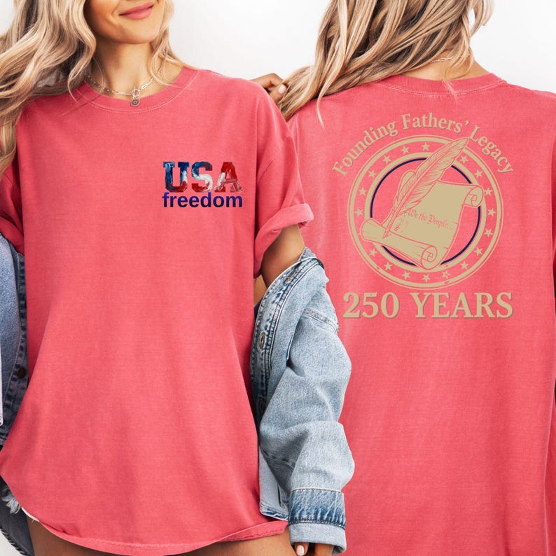 A woman wearing a red t-shirt with the text "USA freedom" and "Founding Fathers' Legacy" printed on it, along with a graphic of a feather and a document. She is also wearing a denim jacket.