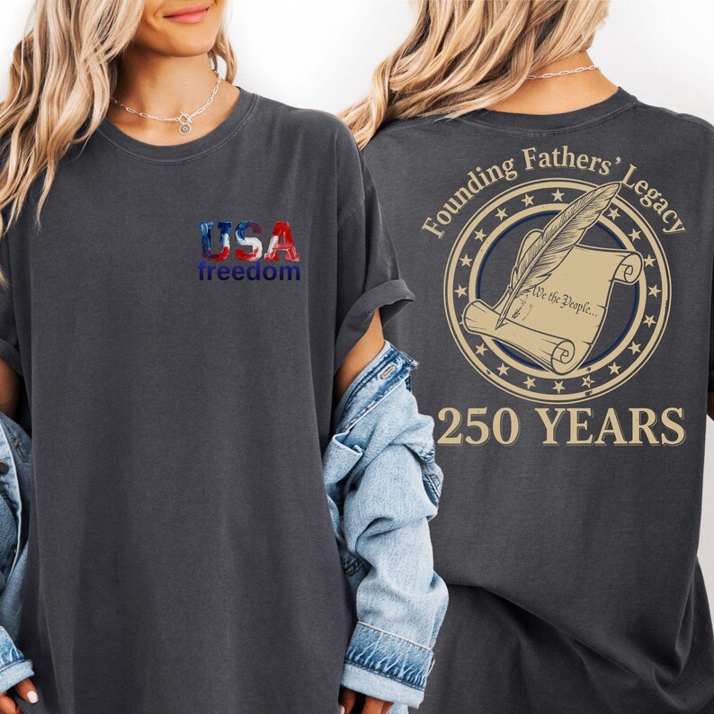 a woman wearing a black t-shirt with a graphic design on the back. The design includes the text "USA freedom" and "Founding Fathers' Legacy" along with a feather and a scroll.