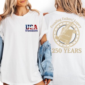 two people wearing white t-shirts with text and graphics on the back.