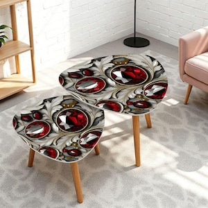 May include: A set of two nesting tables with a triangular shape and rounded corners. The tabletops feature a detailed graphic print of faceted deep red gemstones surrounded by intricate white and grey swirling leaf patterns on a dark background.