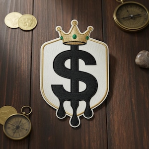 May include: Embroidered patch featuring a black dollar sign with a gold crown, dripping design, and a white background. The patch has a gold border. The image also includes gold coins and a compass on a wooden surface.