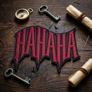May include: Embroidered patch with the word "HAHAHA" in red gothic lettering on a black background. The patch is surrounded by antique keys, a compass, needles, and rolled scrolls on a wooden surface.