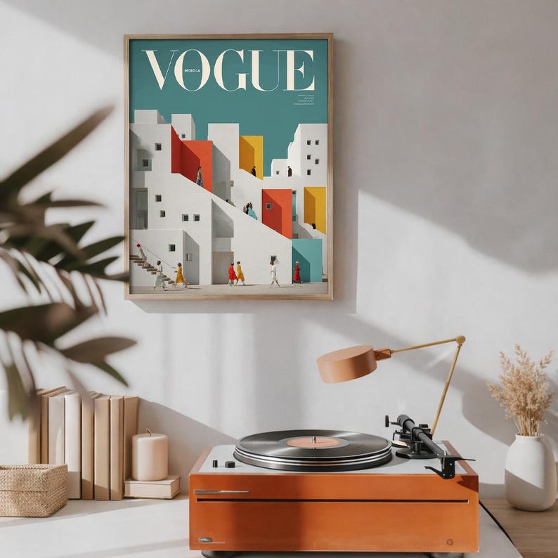 Pu&ograve; includere: Una stampa artistica da parete incorniciata che presenta un'illustrazione architettonica stilizzata con la parola VOGUE in alto. L'opera raffigura edifici bianchi con accenti geometrici rossi, gialli e verde acqua e figure.