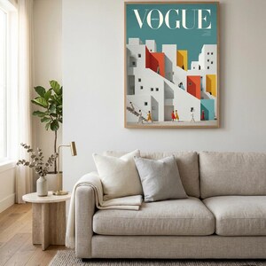 Pu&ograve; includere: Una stampa artistica da parete incorniciata che presenta un'illustrazione stilizzata di edifici bianchi in stile mediterraneo con accenti rossi, gialli e blu. La stampa mostra la parola VOGUE in alto e raffigura piccole figure che camminano su scale.
