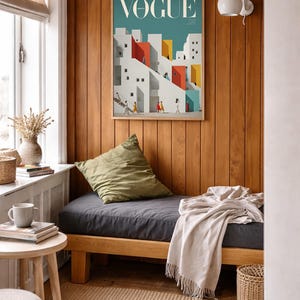 Pu&ograve; includere: Una stampa artistica da parete incorniciata che presenta una copertina della rivista Vogue con un'illustrazione stilizzata di edifici geometrici bianchi, rossi e gialli su sfondo verde acqua, con piccole figure che camminano su scale e sentieri.