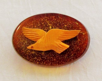 Vintage bakelite bird pin, creamed corn carved bakelite bird on oval bakelite medallion