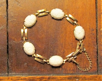 Vintage white glass scarab bracelet in gold tone metal with safety chain