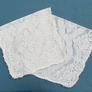 May include: Two white lace doilies with intricate floral patterns. The doilies are delicate and have a scalloped edge.