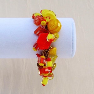 May include: A colorful bracelet with red, yellow, and gold beads. The bracelet is made of glass and metal beads.