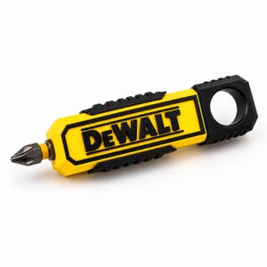 May include: A yellow and black DeWalt screwdriver bit holder featuring a rectangular body with a textured grip, a prominent DeWalt logo in black lettering, and a circular hole at the end for attachment, with a metal Phillips head bit inserted.