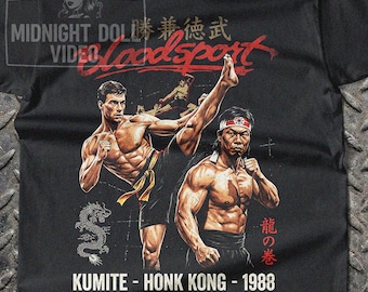 May include: Black t-shirt featuring a graphic of two muscular men in martial arts poses, with the word "Bloodsport" in red. The shirt also includes the text "KUMITE - HONK KONG - 1988" and a dragon graphic.