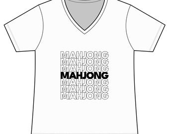 May include: White V-neck t-shirt with the word "MAHJONG" printed in a repeating pattern in black. The word "MAHJONG" is in bold black in the center of the design. The shirt has short sleeves and a gray neckline.