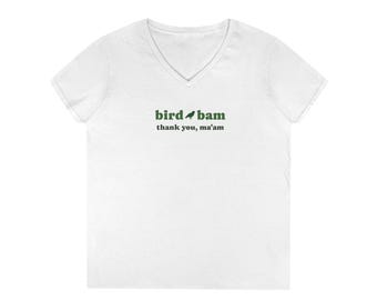 May include: White V-neck t-shirt with the text "bird bam thank you, ma'am" in green. The design includes a small bird graphic. The shirt is made of a soft material.