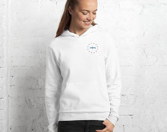 May include: White hooded sweatshirt with a front pocket and a drawstring hood. The sweatshirt features a small design on the upper left chest, with the word "making" in a script font, surrounded by a circle of red and blue dots.