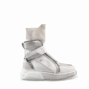May include: A high-top sneaker featuring a white and grey distressed finish, a ribbed knit ankle collar, and a wide hook-and-loop strap across the midfoot. The shoe includes a thick, textured white rubber sole with a subtle gradient grey wash.