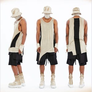 Könnte beinhalten: Ein beiges Tanktop mit schwarzem vertikalem Einsatz, schwarze Shorts, ein beiger Fischerhut und beige Plateaustiefel. Das Tanktop hat einen asymmetrischen Saum. Das Outfit umfasst passende beige Handgelenksmanschetten und eine Gesichtsmaske.