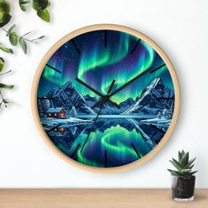 Pode incluir: Um relógio de parede redondo com moldura de madeira clara apresentando uma cena impressa de uma cabana vermelha junto a um lago nevado sob um céu noturno com auroras boreais verdes e roxas. O mostrador tem ponteiros e marcas pretas.