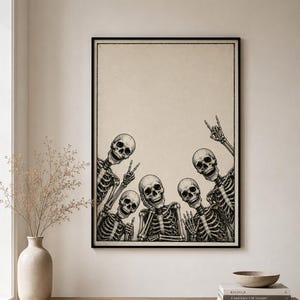May include: A framed wall art print featuring a black and white illustration of five skeletons posing together. The skeletons are depicted from the chest up, with various hand gestures including peace signs and a rock-and-roll hand sign.