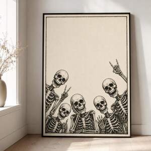 May include: A rectangular wall art print in a black frame featuring a black and white illustration of four skeletons posing together. The skeletons are arranged in a group, with one making a peace sign and another making a rock and roll hand gesture.