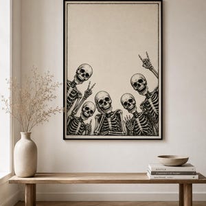 May include: A framed wall art print featuring a black and white illustration of five skeletons posing together. The skeletons are depicted from the chest up, with various hand gestures including peace signs and a rock-and-roll hand sign.