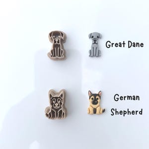 Two labeled dog breed polymer clay cutters and matching clay cutouts showing Great Dane and German Shepherd designs.
