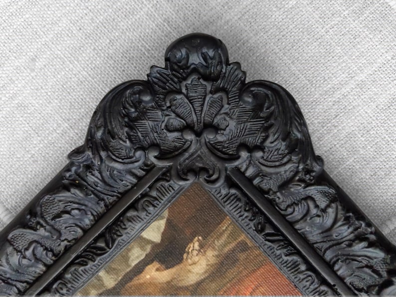 Close up of black frame featuring elaborate floral detailing.
