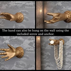 K&ouml;nnte beinhalten: Goldfarbene, handf&ouml;rmige Wandhaken mit strukturierten Handgelenkdetails. Die H&auml;nde sind auf einem grauen Hintergrund mit Wolkenmuster montiert. Der Text "The hand can also be hung on the wall using the included screw and anchor." ist sichtbar.