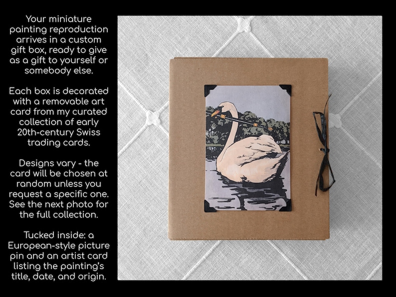 Op de afbeelding: Miniatuur schilderij reproductie in een op maat gemaakte geschenkdoos. De doos is bruin met een zwart lint. De kunstkaart toont een zwaan op water, met een zwart kader. Tekst aan de linkerkant beschrijft het product.